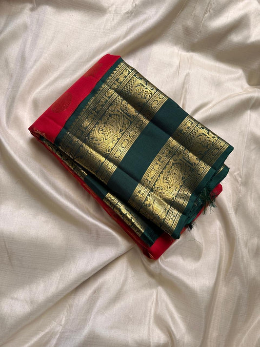 Jyoti – Radiant Tomato Red Kanchipuram Pure Silk Saree
With Mayil 🦚 Chakram ⚙️ Buttas Woven All Over
Rettapet Green Vanasringaram Zari Border 🌿
Handwoven Heritage | Silk Mark Certified