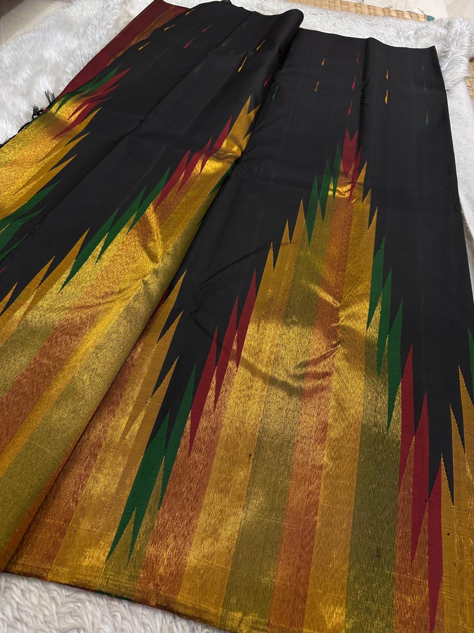 Unfolded Ettukol weave Kanchipuram silk saree showing black body and multicolor flame design