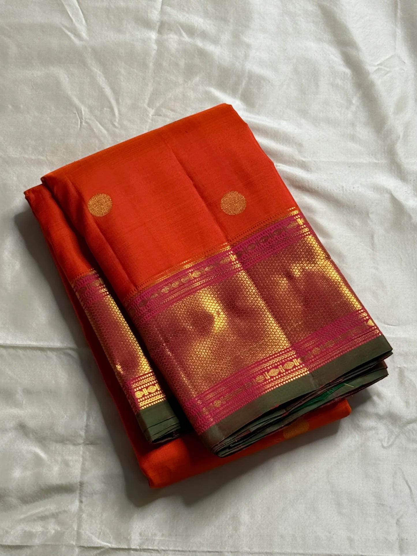 Kalpana  
Pure Silk Kanchipuram Saree  
Burnt Orange with Golden Buttas  
Intricate Magenta & Gold Zari Border