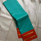 Sharvani blue sea green – sea green  Checked Silk Saree with an Orange red  shot color Zari Border & Vibrant Pallu A timeless silk saree featuring a cream body with delicate red checks, complemented by a striking churan orange  zari border pallu.