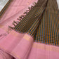 Nirai – A Madras-Inspired Kanchipuram Silk in Amber & Pastel Pink.
Woven with fine podi kattam checks in black, amber orange, and grey.
The pastel pink border with pillayar moggu detailing adds softness, with a  seer zari pallu
