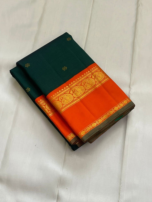 Pachai Kesar Mayil — Kanchipuram Pure Silk

 Bottle-green body with dainty gold floral buttas

Contrast marigold-orange korvai borders with temple edging

Rich gold-zari paisley scrolls; striped orange pallu with tassels

Silk Mark Certified | Free Shipp
