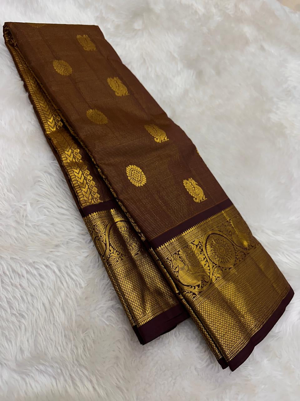 Handwoven Pure Silk Kanchipuram saree in deep rustic brown with a soft petal pink pallu with ornate Mayil Chakram zari buttas.