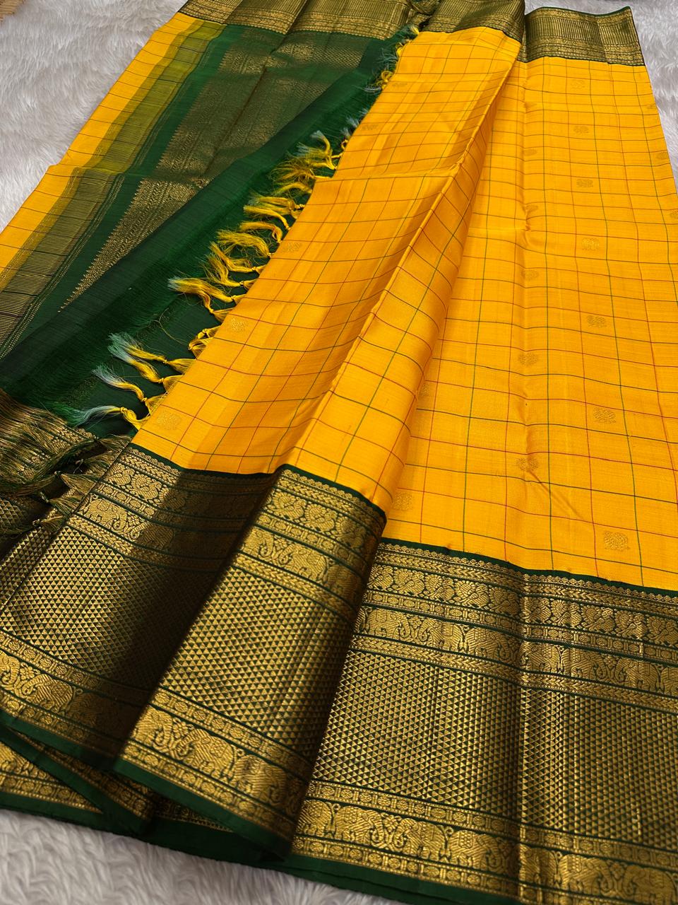 Manjal Pachai Kattam
Pure Kanchipuram Silk Saree – Marigold Yellow Body with Green Checks & Petite Zari Buttas
Deep Green Korvai Borders with Rich Gold Zari Weave & Traditional Elephant Motifs
Silk mark certified , ships in 2 weeks