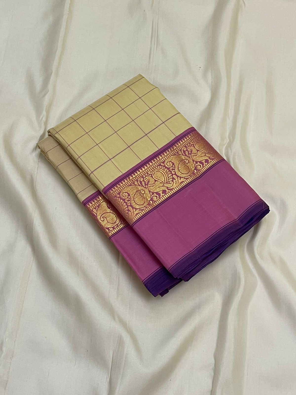 Lotus Kattam — Pure Kanchipuram Silk Saree
Butter-cream body with fine rose-pink kattam checks ✨
Rani-magenta zari border with lotus vines & paisley motifs 💖
Silk Mark Certified ✅ Free USA Shipping ✅ Ships in Two Weeks ✅