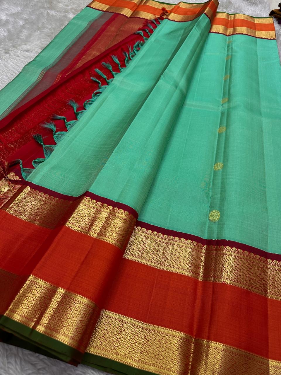 Poomugam Pachai
Pure Silk in Tender Mint & Kumkum Red
Zari-Woven Grandeur in korvai  Contrast