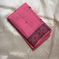 Folded pink pure Kanchipuram silk saree with dark woven border and small round motifs on ivory fabric backdrop