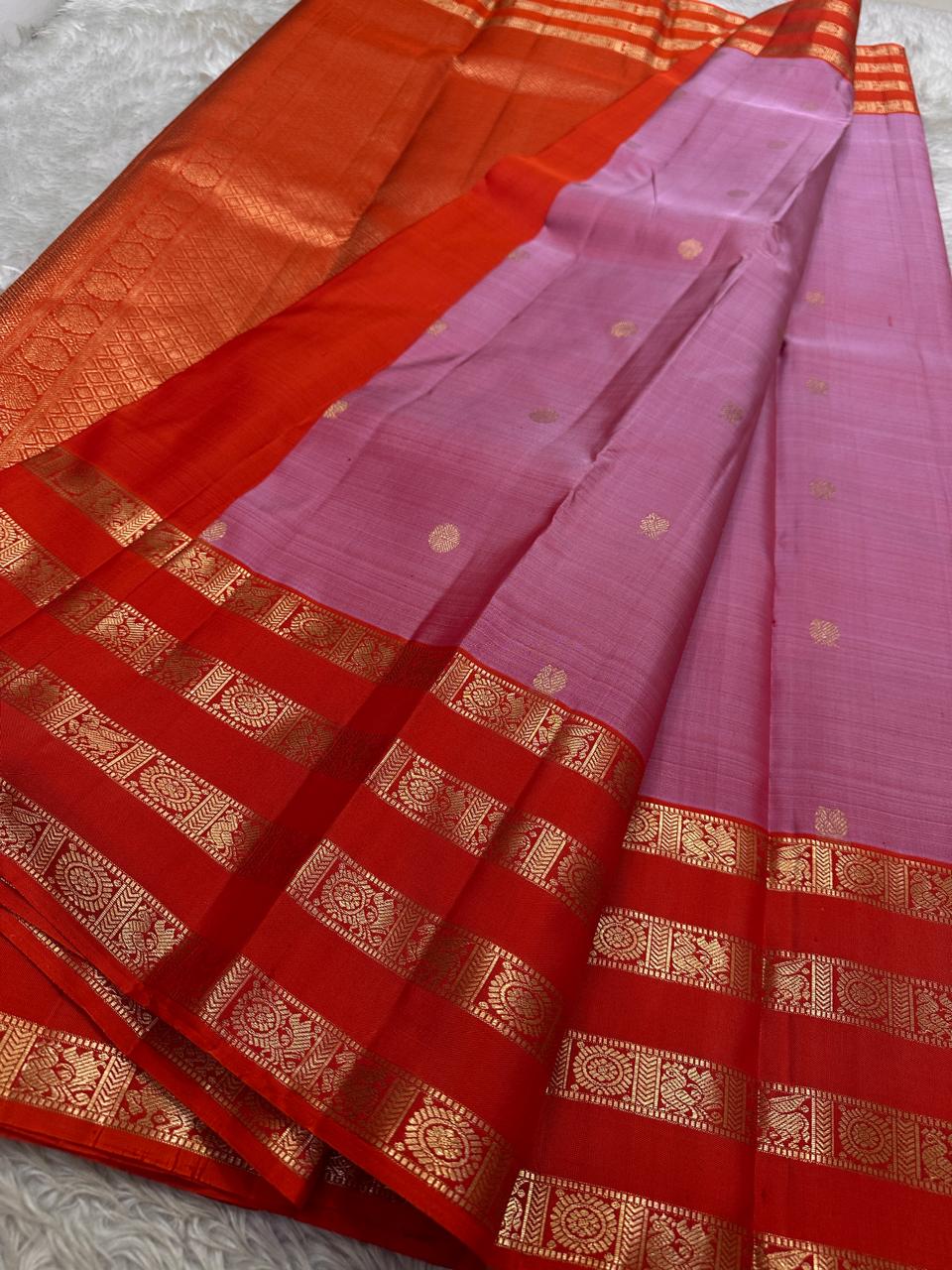 Thamarai Vermillion — Pure Kanchipuram Silk Saree
Soft orchid-pink body with zari lotus buttas and striking vermillion korvai borders, finished with a radiant orange pallu in intricate zari weave.
Silk Mark Certified • Blouse Stitching Available ($30) •