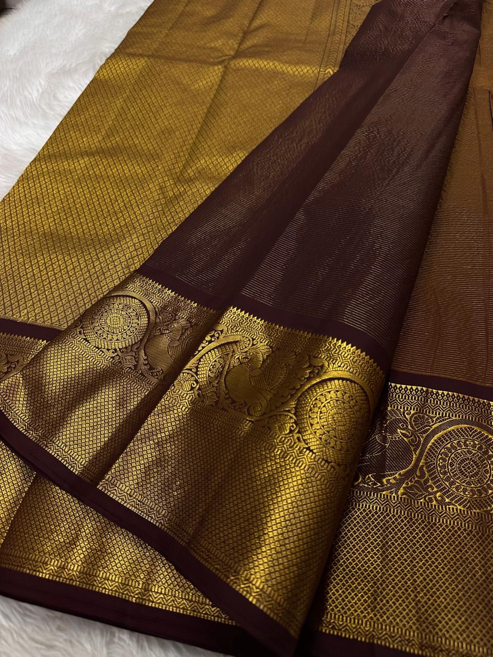 Close view of ornate Mayil Chakram zari buttas on the brown silk body.