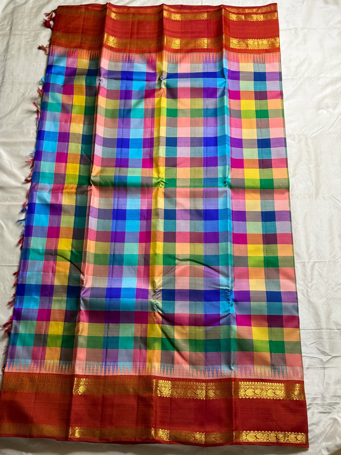 Ratna Mala ✨ – Pure Kanchipuram Silk Saree
Multicolor Checked Body in Vibrant Jewel Tones
Deep Red Korvai Border with Gold Zari Weaving
Grand Red Zari Brocade Pallu with Traditional Motifs
A Regal Handwoven Drape – Perfect for Weddings & Festive Wear!