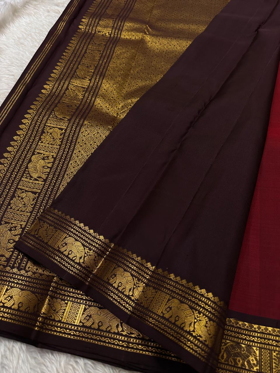 Ember ✨
Pure Kanchipuram Silk Saree in Ember Red & Coffee Brown
Ember-red body with delicate gold zari buttas
Rich coffee-brown elephant border with zari vines

Silk Mark Certified, delivery in 2 weeks