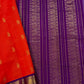 An exquisite blend of tradition and vibrancy, this silk cotton saree features a radiant orange body adorned with elegant gold zari buttas, The rich contrast border and pallu in royal purple and intricately woven with traditional gold zari motif