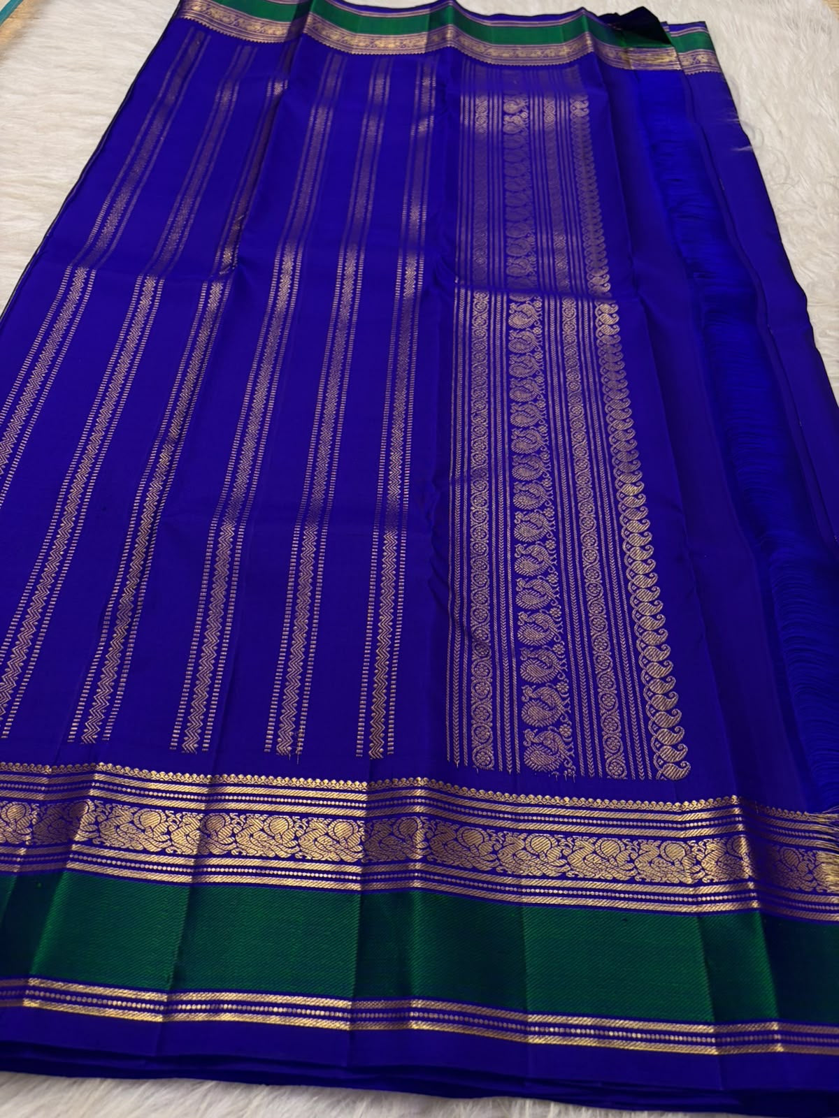 Vivid Neelam Blue and Emerald Green pure silk Kanchipuram Varisaipet saree, folded handwoven silk fabric.