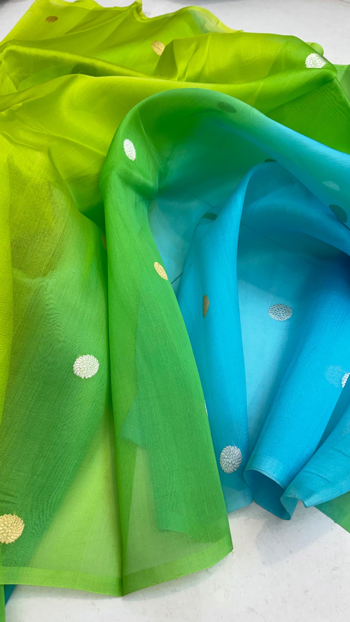 Pure Ektara Kora Silk Handloom Banarasi Saree
Parrot green to aqua blue ombré • Kadhua sona-roopa floral buttas • Raw-Mango style minimal weave
Silk Mark Certified ✅ • Free USA Shipping ✅ • ships in two weeks ✅