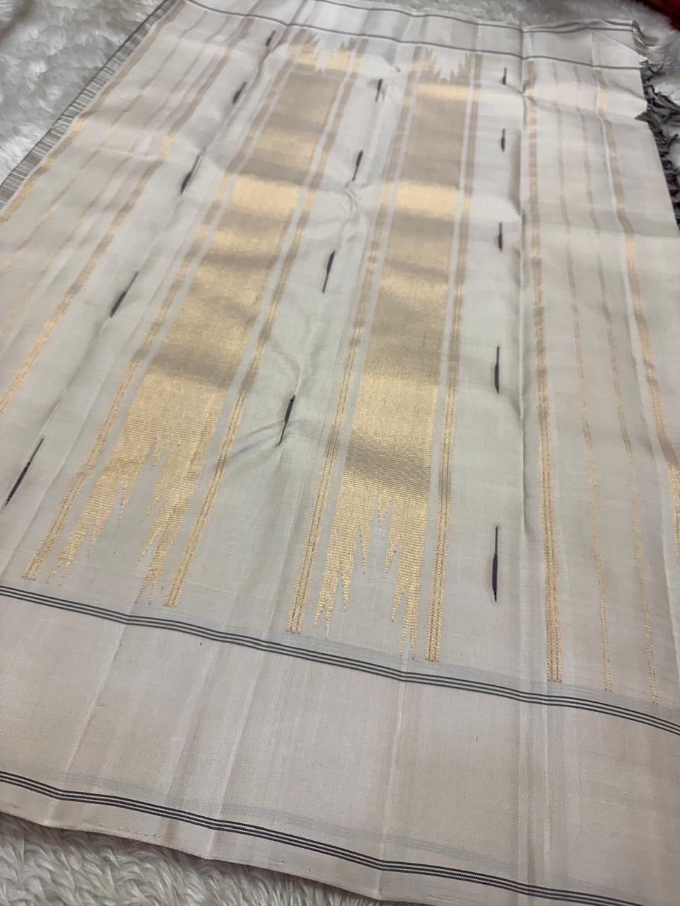 Nirai – Pure Kanchipuram Silk in Sandal, Grey & Mauve Checks.
Framed with a subtle sandal border and navy thread stripes, the saree features a striking pallu woven with thazhampoo reku and beautiful mullai mottu motifs in navy silk thread