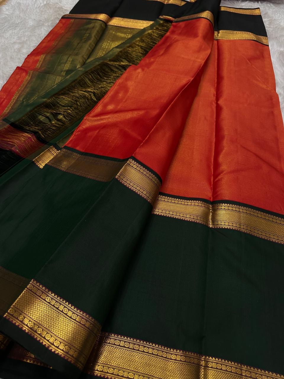 A festive radiant orange silk saree with a rich vairaoosi all over bottle green  border, woven to celebrate tradition with a bold flair.