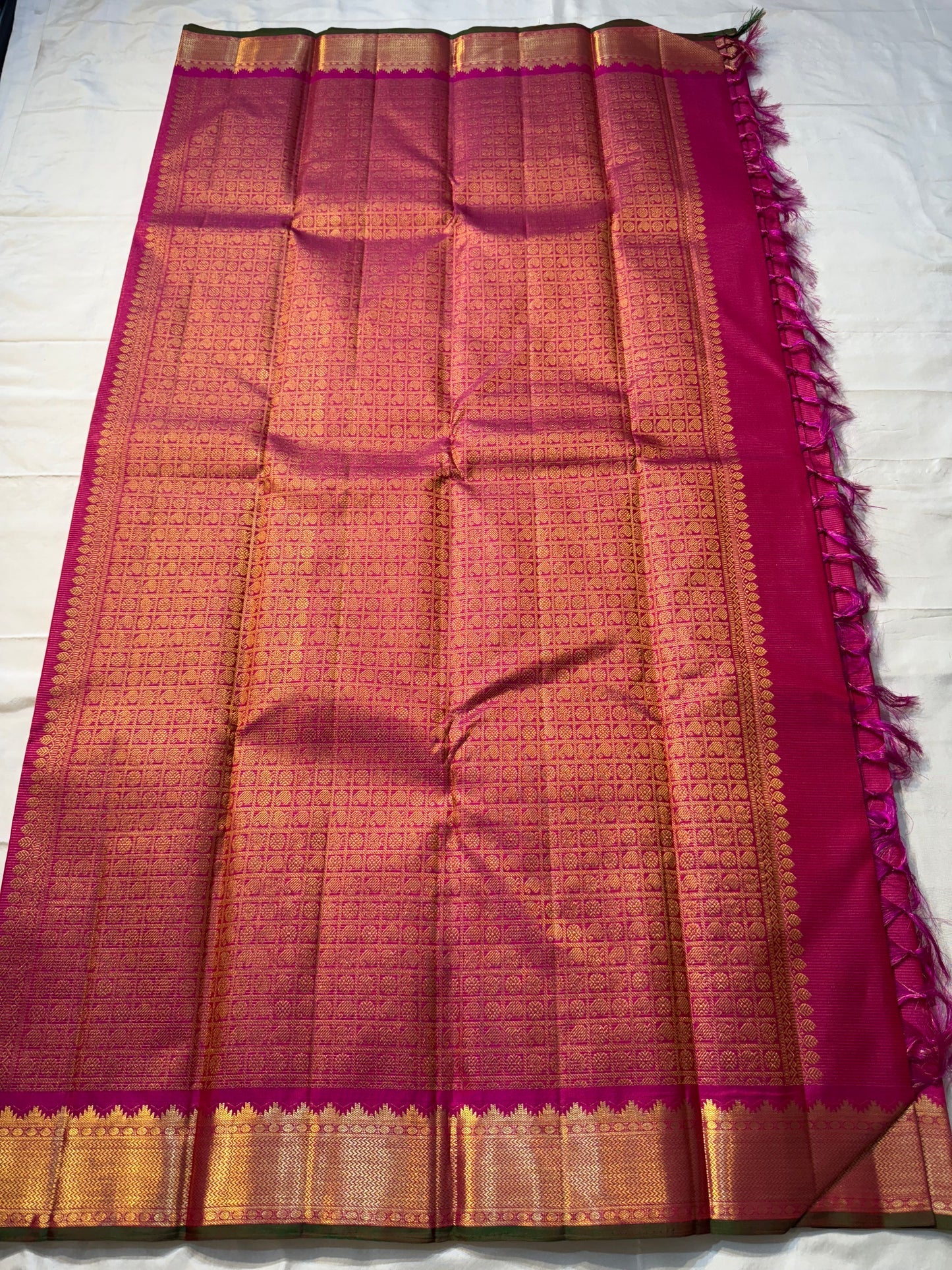 Rani Vairaoosi – Pure Kanchipuram Silk 💗

Fine Pinstriped Weave with Gold Buttas ✨

Antique-Gold Zari Border & Green Selvedge 🌿

Grand Zari Brocade Pallu with Medallion Checks 🪔

Silk Mark Certified • Ships in Two Weeks • Free USA Shipping