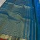 Peacock Teal Ilai Butta – serene teal body with copper-gold zari borders

Pure Kanchipuram silk • dainty leaf (ilai) buttas scattered across the body
Rich teal zari pallu

Silk Mark Certified | Fall & Pico Done | Blouse Stitching Available ($30)