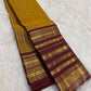 Close view of gold zari border registers on a turmeric yellow and maroon Kanchipuram silk saree