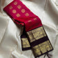 A regal  shot tomato red pink Kanchipuram silk saree features elegant chakram and mayil gold zari buttas woven across the body. Brown contrast rettapet border and Pallu vanasringaram details