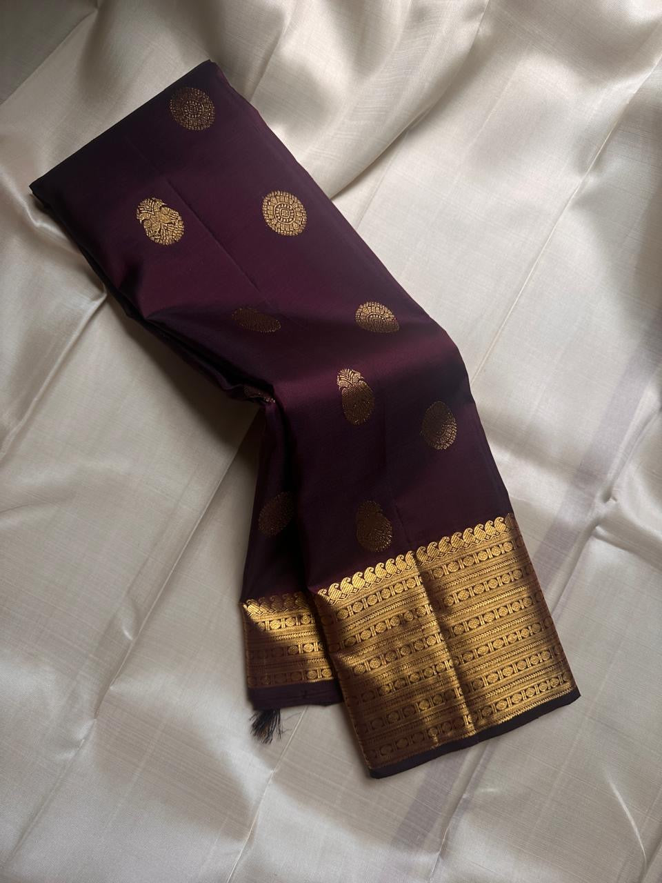 Cholai – Orchard at Dusk ✨ A pure Kanchipuram silk in deep purplish-brown, adorned with regal Gandaberunda 🦅 and delicate Kamalam 🌸 motifs. Its gold zari border layers Varisaipet, mango paisley 🥭, Rudhraksham, and Vanki for a true heritage masterpiece