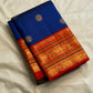 Royal blue silk saree close-up showing circular coin buttas and rich red-gold zari border