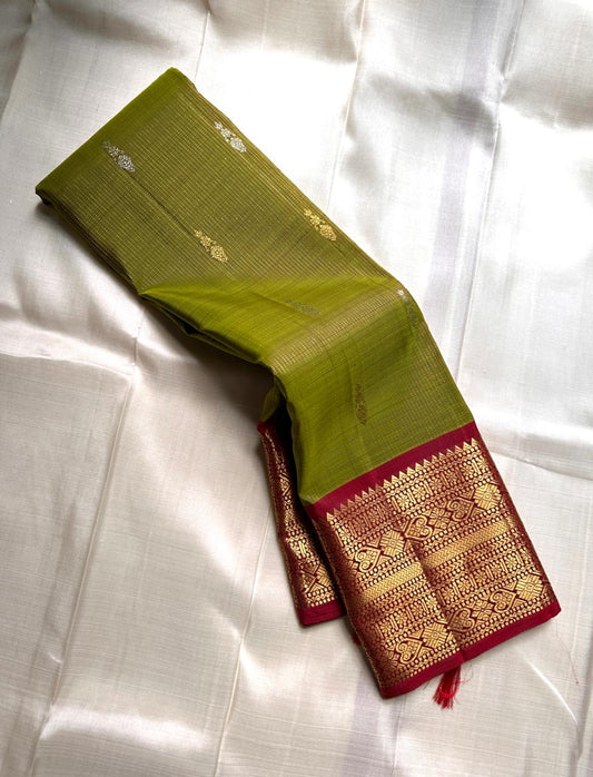 Golden Emerald Gleam ✨ – Pure Kanchipuram Silk Saree
Parrot Green & Turmeric Shot with Gold & Silver Leaf Buttas 🌿
Crimson Red Korvai Border with Temple Peaks  ❤️
Grand Crimson Pallu 🌟

Silk Mark Certified, delivery in 2 weeks