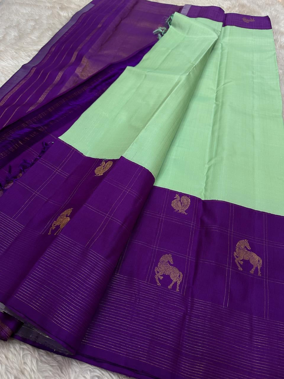 Ashva ✨ – Violet & Mint Pure Silk Kanchipuram Saree
Gold Zari Horse & Rooster Motifs in Kattam Checks
Linear Zari Border with Grand Violet Striped Pallu
Mint Green Blouse with Zari Border Included
Silk Mark Certified | Fall & Pico | Blouse Stitching ($30)