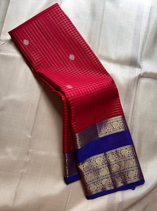 Gargi ✨ – Ruby Red Kanchipuram Pure Silk Saree
with Gold Kattam Checks & Rosette Buttas
Broad Royal Blue Korvai Zari Border 🌸
Opulent Blue Brocade Pallu with Fine Zari Weaving
A Timeless Heirloom of Elegance & Tradition