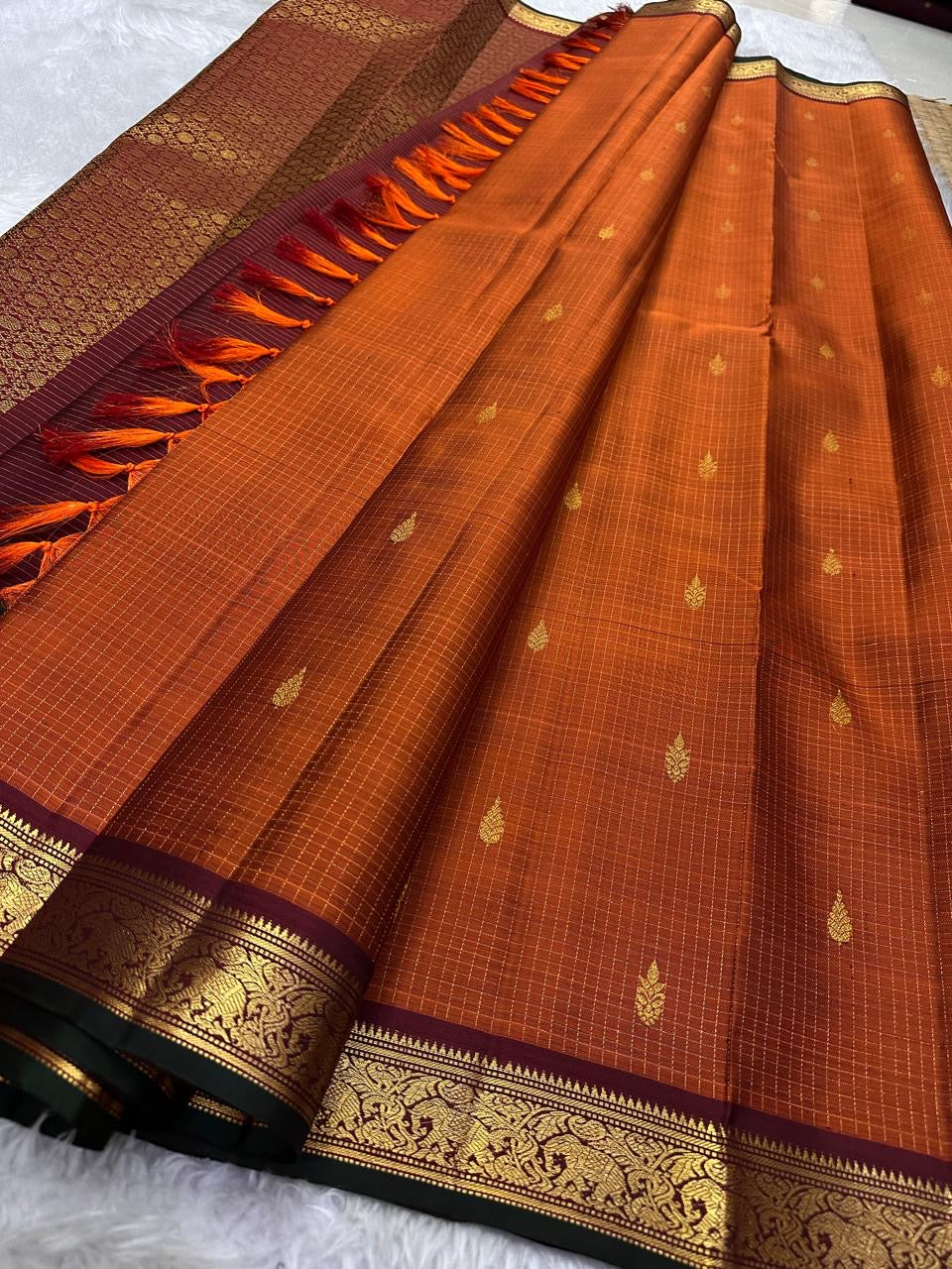 Rust Orange Zari Kattam — Petite Border | Pure Kanchipuram Silk ✨
Rust-orange body with fine zari kattam checks & gold paisley buttas 💫
Silk Mark Certified • Free Shipping within USA • Ships in Two Weeks ✅