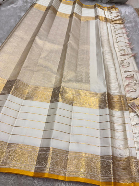 Kiran ivory whiteb oosi kattam  ✨ – ivory and gold  Kanchipuram Pure Silk Saree
Korvai Gold Zari Border with Elephant & Floral Motifs
Body Woven in Zari Kattam Checks with Scattered Gold Buttas
Grand Zari Brocade Pallu | Silk Mark Certified |