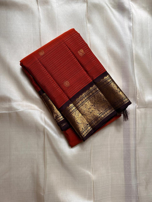 Amber Plume – Pure Kanchipuram Silk Saree
Amber Burnt-Orange Body with Vaira Oosi Stripes
Rudhraksham & Mayil Zari Woven Buttas All Over
Contrast Coffee-Brown Border with Peacock Motif Panel

Silk Mark Certified, delivery in 2 weeks