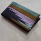 Deep charcoal-black Kanchipuram silk in a traditional Ettukol weave with delicately contrasting pastel threads.