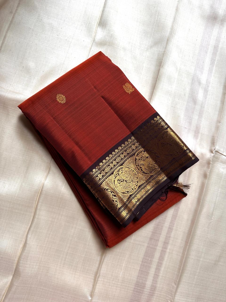 Rust Simha – Pure Silk Kanchipuram Saree
Rust Orange Body with Petite Gold Floral Buttas
Black Korvai Contrast Border with Simha & Annapakshi
Grand Zari Pallu
Comes with Contrast Black Blouse Piece with Zari Border silk Mark certified, ships in 2 weeks