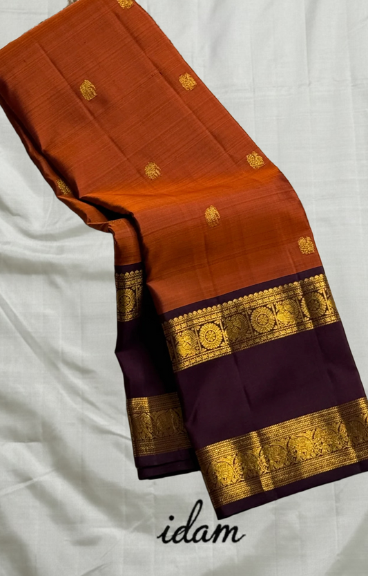 Poovizhi Rust Orange — Pure Kanchipuram Silk Saree
Deep aubergine body with rust-orange korvai borders & rich zari floral motifs
Silk Mark Certified • Blouse Stitching ($30) • Free Shipping within USA • Ships in Two Weeks