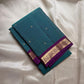 Folded teal pure Kanchipuram silk saree with purple zari woven border, shipped from New Jersey USA.