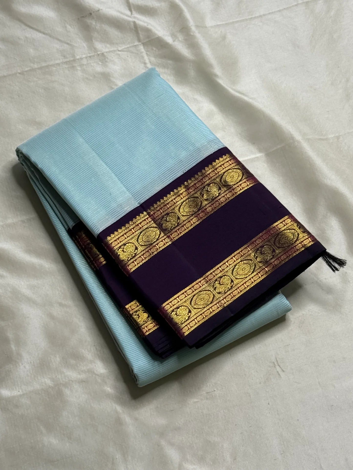 Neel Pushpa – Pure Kanchipuram Silk Saree
Pastel Powder Blue Vairaoosi Weave Body
Deep Violet Korvai Border with Zari Medallions
Antique Gold Zari Brocade Pallu, Diamond Jaal

Silk Mark Certified, delivery in 2 weeks