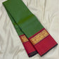 Green silk saree folded lengthwise showing a pink border with gold zari woven pattern and dark edge piping.