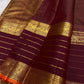 Close-up of maroon Kanchipuram silk saree pallu featuring dense gold zari weaving and traditional motif panels.