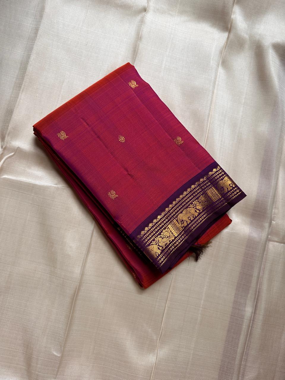 Anju ✨ – Red & Rust-Orange Shot Kanchipuram Pure Silk Saree
with Majestic Elephant & Peacock Motifs
Regal Deep Purple Korvai Contrast Border
Opulent Gold Zari Brocade Pallu