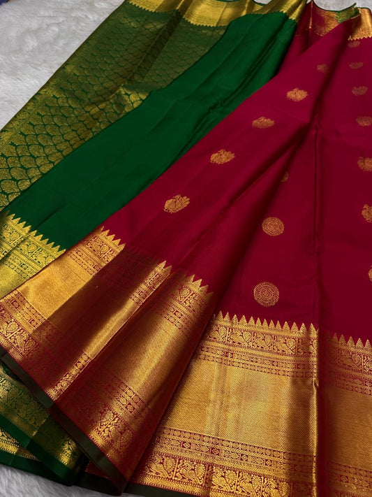 A timeless drape in sindoor red and betel leaf green emerald grace! Mayil chakram butta peacock border