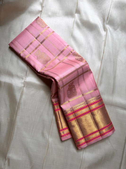 Blush pink Kanchipuram silk saree draped in a pleated stack showing gold zari checks and peacock buttas – Idam Living