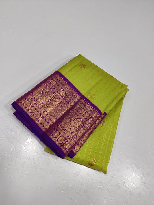 Verdant Gold ✨ – Parrot Green & Violet Pure Kanchipuram Silk Saree
 Gold Zari Buttas in Kattam Weave
Violet Korvai Border with Peacock & Floral Zari Motifs
Grand Violet Brocade Pallu with  Tassels done 
Violet Blouse with Zari Border | Silk Mark
