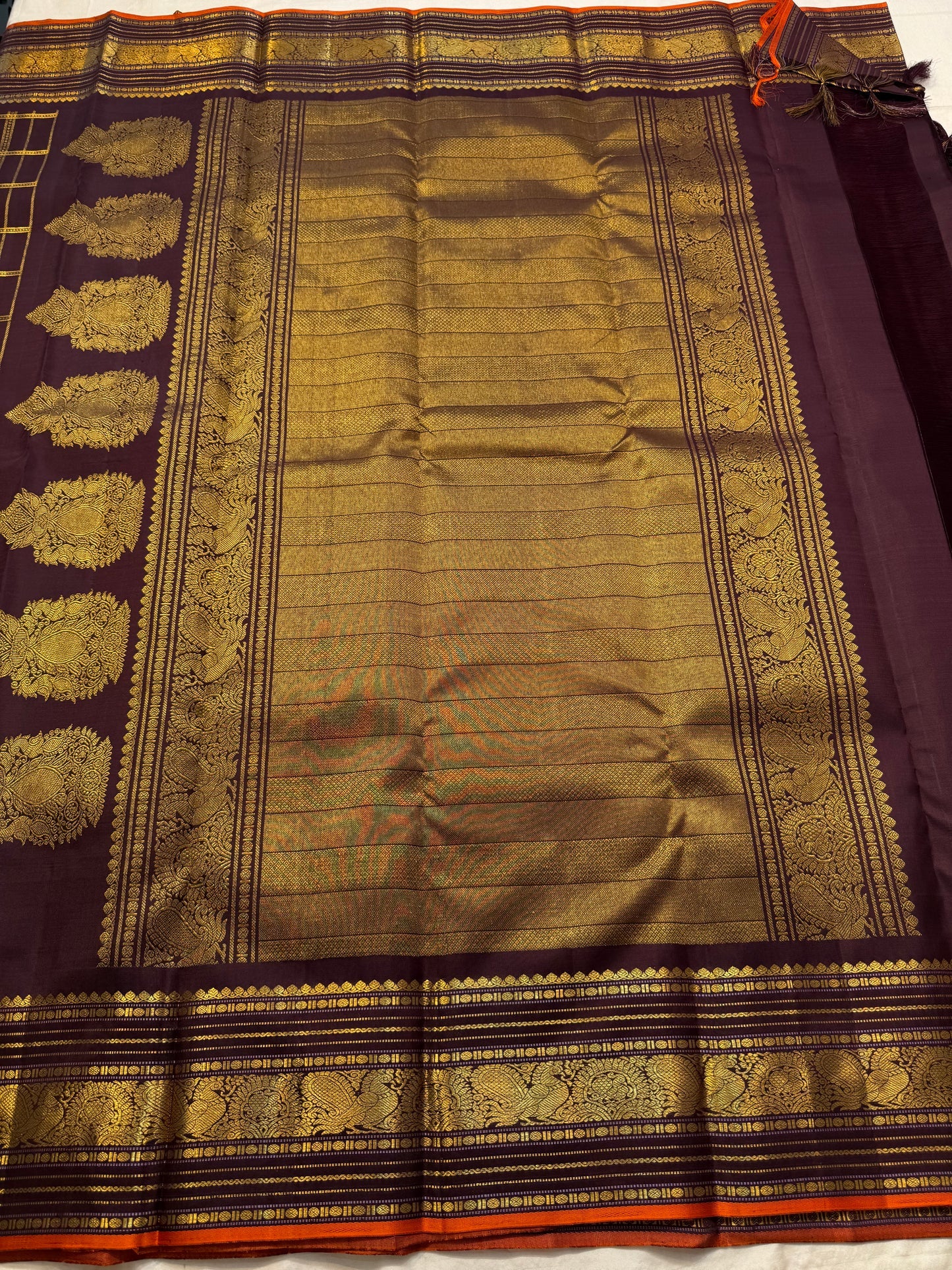 Then Thuli — Pure Silk Kanchipuram Saree
Coffee plum with gold kattam checks & mango buttas
Antique-gold peacock borders, brocade pallu, tasselled finish
Silk Mark Certified ✅ • Ships in Two Weeks ✅ • Free USA Shipping ✅