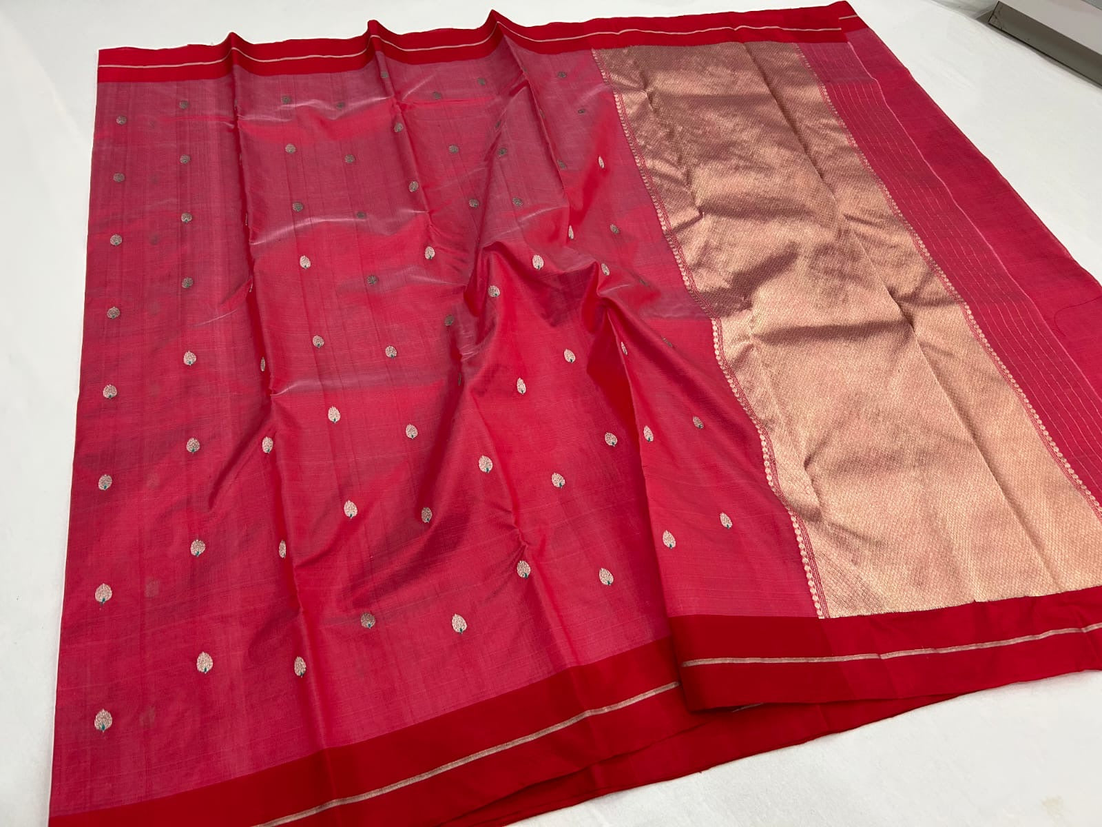 Close view of rose pink handloom Chanderi silk with small metallic leaf buttas and contrasting green accents