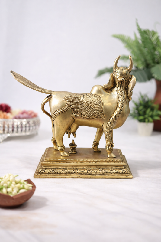 Back view of solid brass Kamadhenu sacred sculpture showing detailed wing engravings and traditional pedestal 8 inch