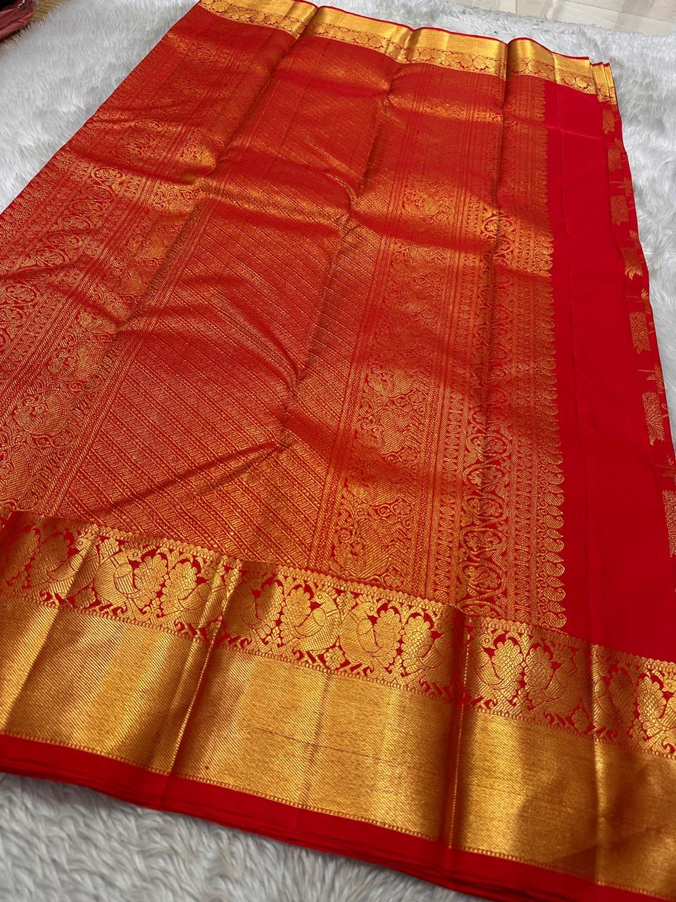 Tanvi – Vermillion Red Kanchipuram Pure Silk Saree with Floral Zari Jaal & Baavanji Border
Bold, radiant, and intricately woven varisaipettu Pallu