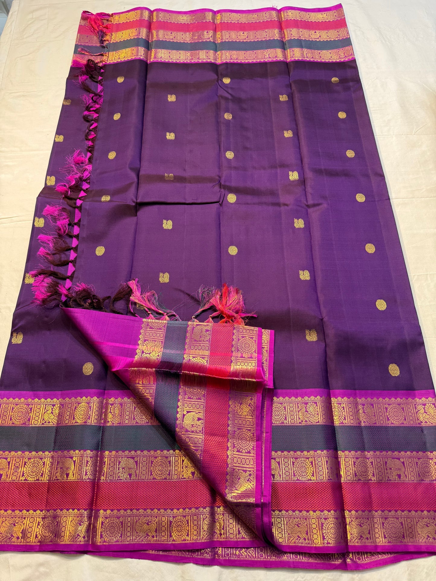 Madhurima — Pure Kanchipuram Silk (Royal Purple × Magenta)
Royal purple body with gold coin buttas, magenta korvai border with zari-woven elephant & peacock panels, and rich magenta pallu.
Silk Mark Certified • Free Shipping within USA • Ships in Two Week