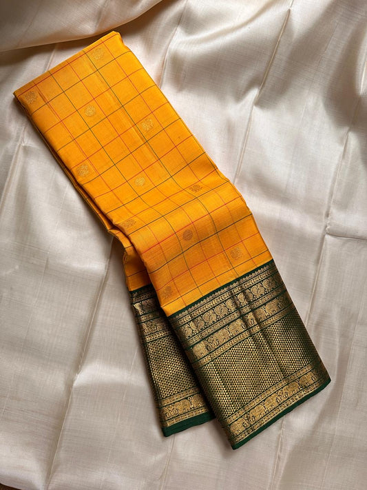 Manjal Pachai Kattam
Pure Kanchipuram Silk Saree – Marigold Yellow Body with Green Checks & Petite Zari Buttas
Deep Green Korvai Borders with Rich Gold Zari Weave & Traditional Elephant Motifs
Silk mark certified , ships in 2 weeks