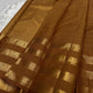 vasantham  Brown– Handwoven Kanchipuram Silk Saree A poem in Brown silk. The body glows in a serene earthy Brown, softly accented by delicate gold vertical lines and dainty gold zari buttas that glint like little blessings.